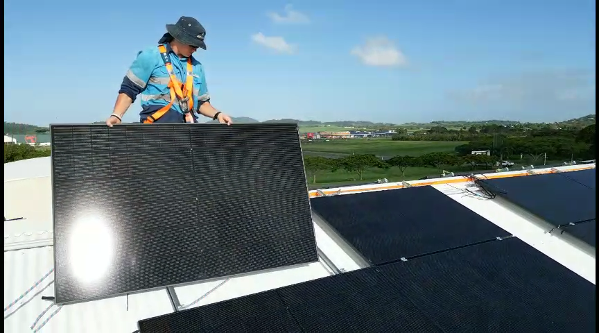 A JSR team member installing solar panels on a Mackay rooftop