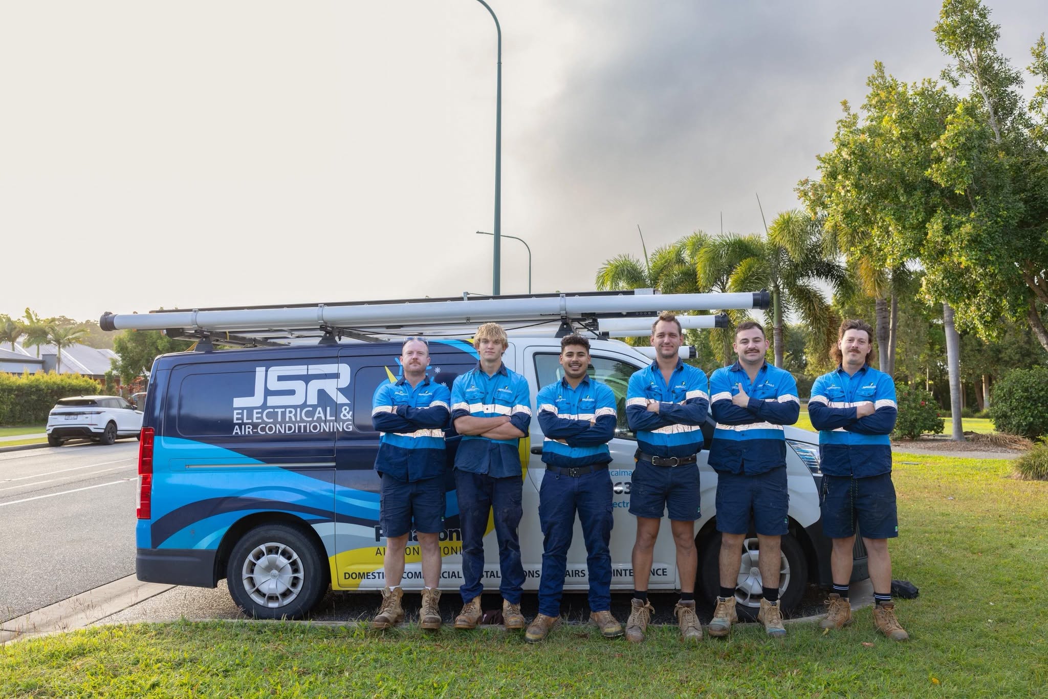 The JSR Electrical & Plumbing team with their service vans in Mackay