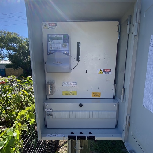 Residential electrical switchboard with voltage warning stickers, a power outlet and wire, providing electrical connectivity.